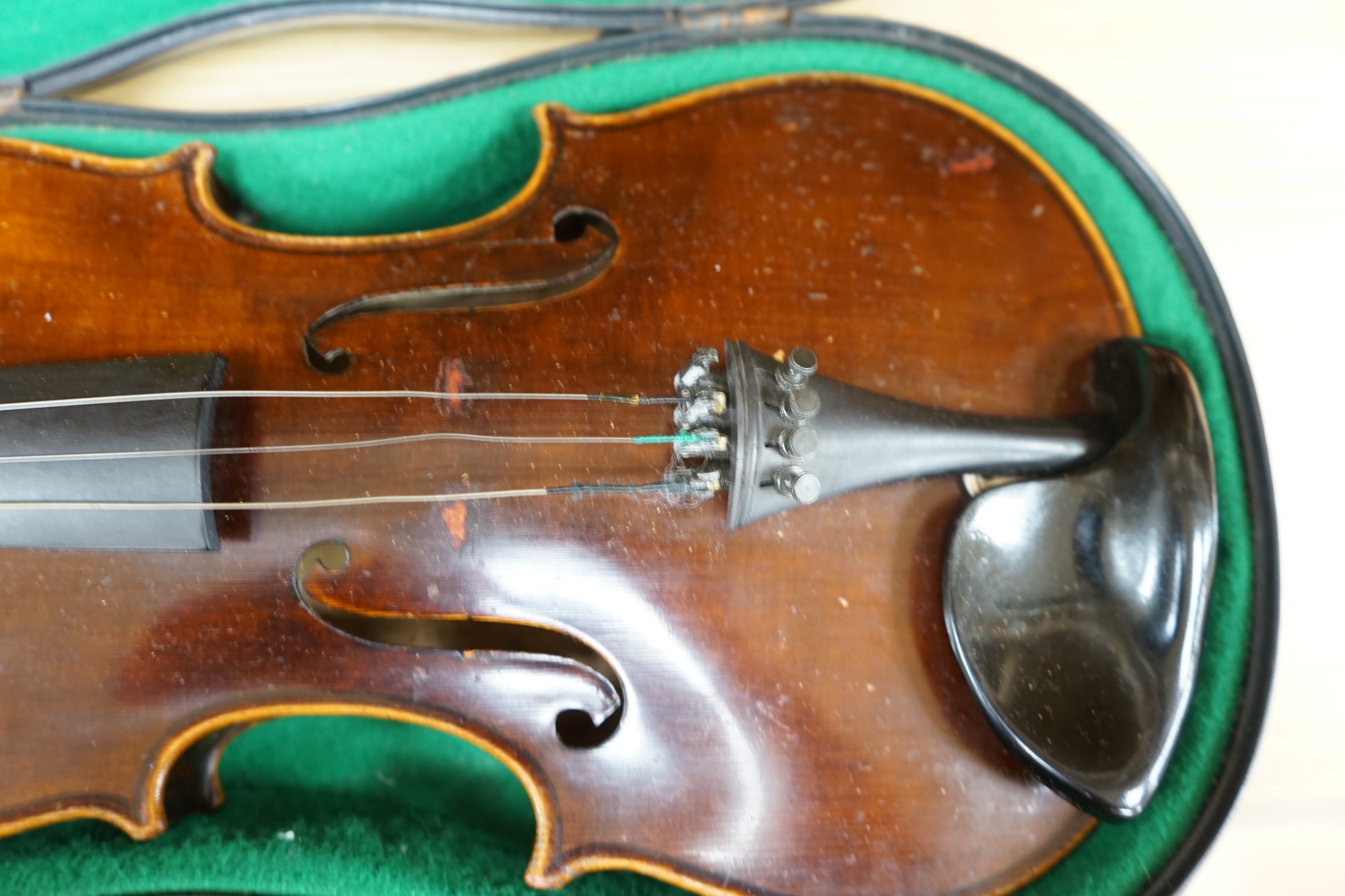 An early to mid 20th century violin, interior label reads ‘Copy of Antonius Straduarius made in Germany’, cased with bow, back measures 33.5cm. Condition - fair to good